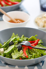 Plate with fresh Greek salad on table