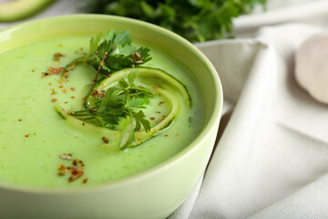 Bowl with green gazpacho on table, closeup