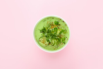 Bowl with green gazpacho on color background