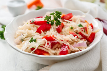 Plate with tasty sauerkraut on light background