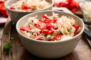 Bowls with tasty sauerkraut on table