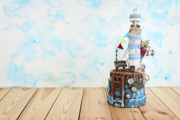 Naklejka premium nautical concept with driftwood lighthouse over wooden table