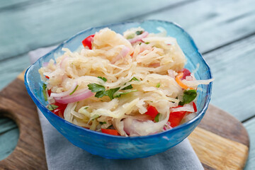 Bowl with tasty sauerkraut on color wooden background