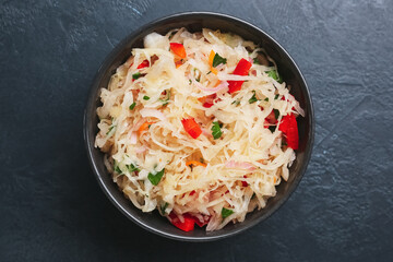 Bowl with tasty sauerkraut on dark background