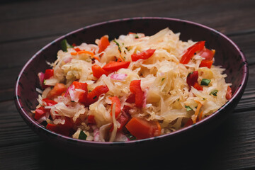 Plate with tasty sauerkraut on dark wooden background