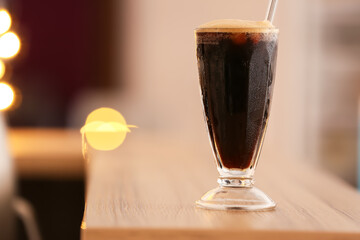 Glass of tasty iced coffee on table