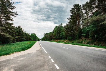 Fototapeta na wymiar Empty country asphalt road near forest in summer time.