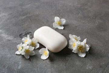 Soap bar and flowers on dark background