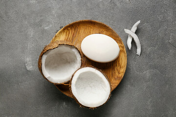 Plate with soap bar and coconut on dark background