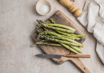 Asparagus cooking concept, top down view on a cutting board with fresh bunch of asparagus, spring healthy cooking idea