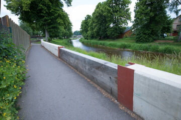 Modern flood protection wall in the style of the historic city wall. Permanent measures against floods. Dikes, gate valves, gates and walls. 
Flood gates protecting city against flooding from stream.