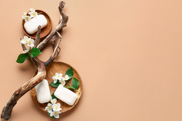 Composition with soap bars, flowers and tree branch on color background