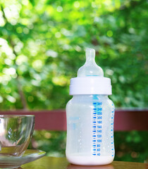 empty baby feeding bottle. rest with a baby in nature