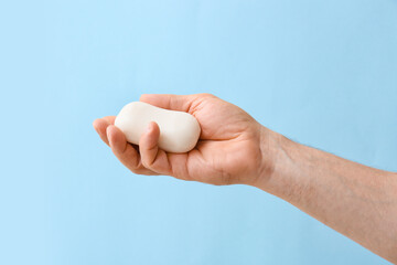 Male hand with soap on color background