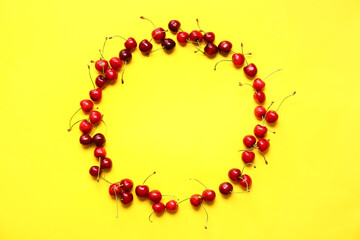 Frame made of tasty ripe cherry on color background