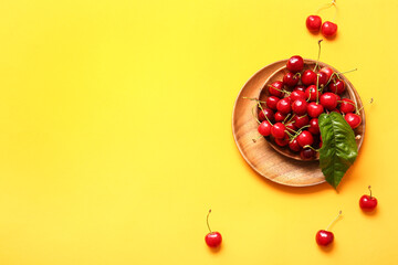 Bowl with tasty ripe cherry on color background