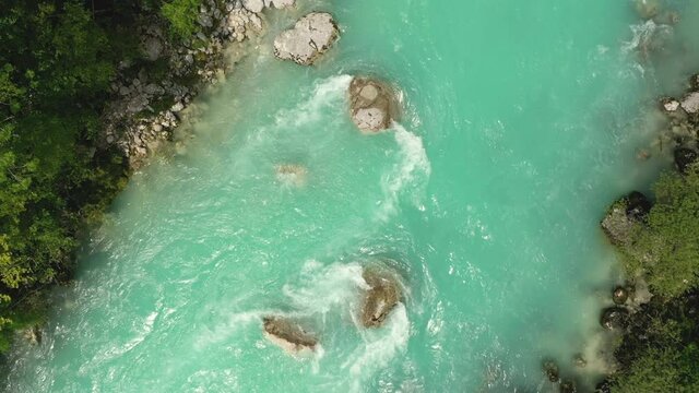 Aerial - Descending above Soča river. Top down view of emerald water 