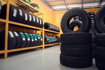 Large warehouse of car tires, rack with customer car tires in warehouse of a tire dealer - obrazy, fototapety, plakaty