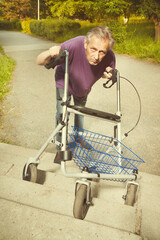 Older man overcoming obstacles with his four wheel rollator walker