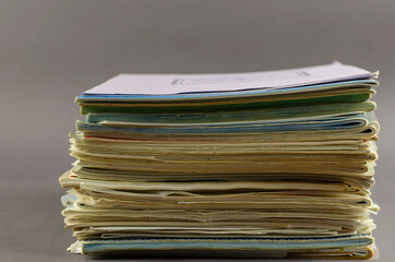 Stack of old school exercise books on a gray background.