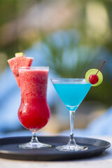 Red and Blue Cocktails in Different Glasses with Blurred Background