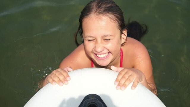 happy little girl learn to ride on surf