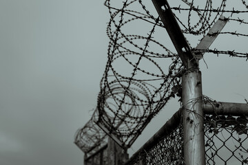 Prison security fence. Barbed wire security fence. Razor wire jail fence. Barrier border. Boundary security wall. Prison for arrest criminals or terrorists. Private area. Military zone concept.