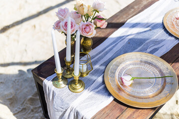 Romantic Wedding Table Top Layout Table Spread no people tropical location with gold cutlery and scenic view of sunset on the beach