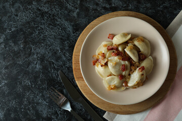 Concept of tasty food with vareniki or pierogi on black smokey table
