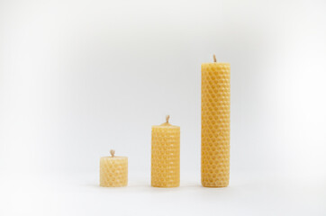 Yellow wax candles with a honeycomb pattern on a white background. Interior and esoteric accessories