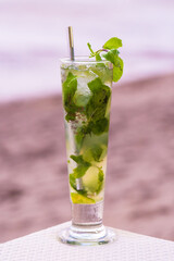 Mojito Cocktail on a beach  with a metal straw with a white sea view background