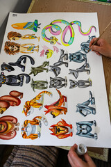 The animator draws with a pencil and draws characters from cartoons, comics or puppet shows....