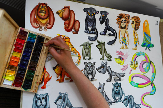 The animator draws with a pencil and draws characters from cartoons, comics or puppet shows. Mowgli's play. Preparing to make a doll. The designer creates sketches. Comics, cartoons, puppet theater