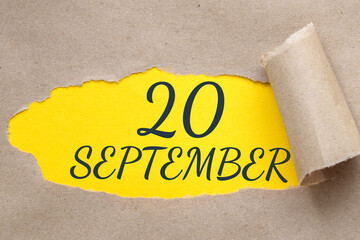 september 20. 20th day of the month, calendar date.Hole in paper with edges torn off. Yellow background is visible through ragged hole.Autumn month, day of the year concept
