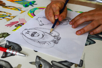 The animator draws with a pencil and draws characters from cartoons, comics or puppet shows....