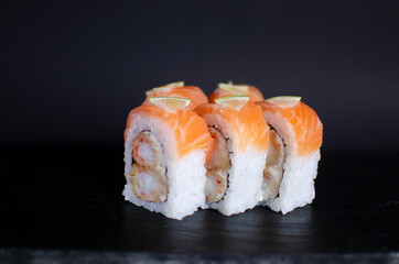 shrimp and cheese sushi topped with salmon and lime. Side view