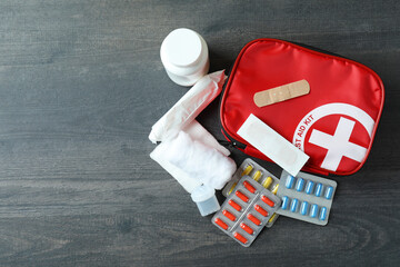 First aid medical kit on dark wooden background