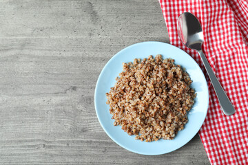 Concept of tasty eating with buckwheat on gray table
