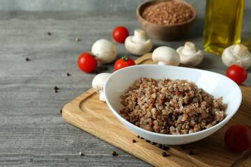 Concept of tasty eating with buckwheat on gray textured table