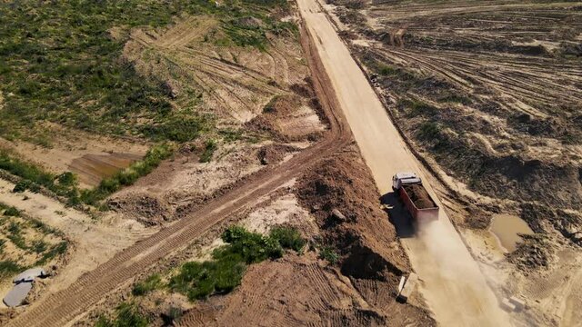 Mining truck transported sand from the open pit. Dump truck working in quarry. Arial view of the opencast mine. Limestone and gravel is excavated from ground. Mining industry.