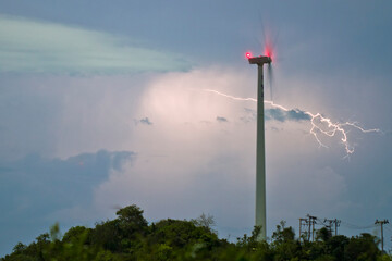 Lightning behind a wind turbine in a storm rainfall