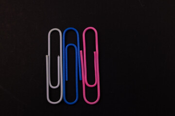 Colorful paper clips on black background