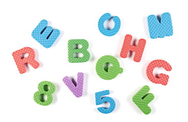 Colorful foam alphabet letters and numbers for children isolated on white background, top view