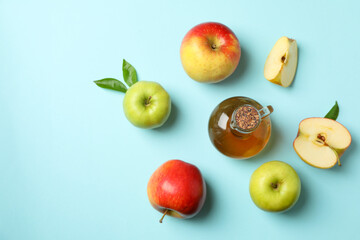Homemade apple vinegar and ingredients on blue background