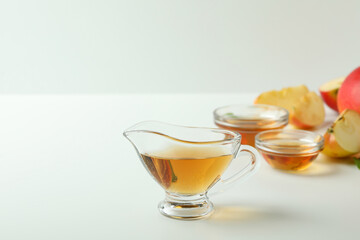 Homemade apple vinegar and ingredients on white table
