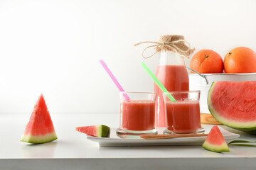 Containers with watermelon juice and fruit white isolated background front
