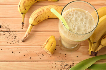 Banana smoothie on wooden table top view
