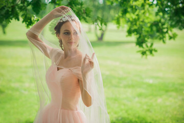 Fototapeta na wymiar Tender elegant young bride in pink pastel wedding dress, fashionable fancy collection