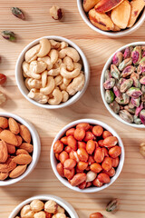 Cashews, peanuts and many other nuts, shot from above on a rustic wooden table
