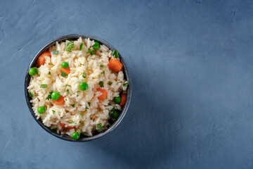 White rice with veggies, shot from above on a blue background with copy space